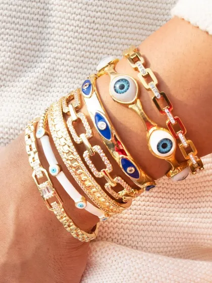 A close-up of my favorite kind of arm party. This stack features our white enamel evil eye bangle, a studded link cuff, and the original evil eye piece. It’s the perfect mix of trendy and timeless.
