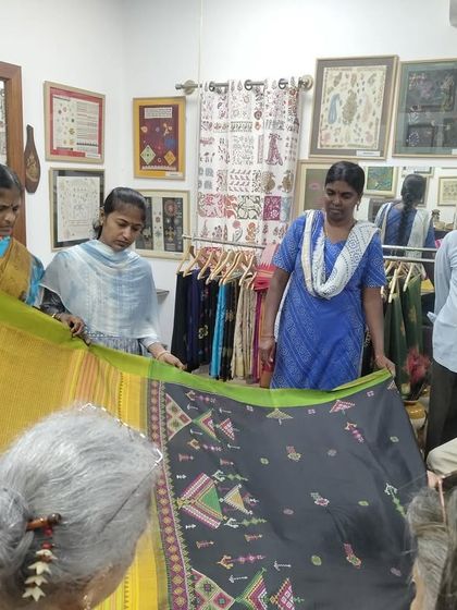 Students from SKV School of Design examining a hand-embroidered Ilkal saree. These visits provide valuable, real-world lessons in craft and design.