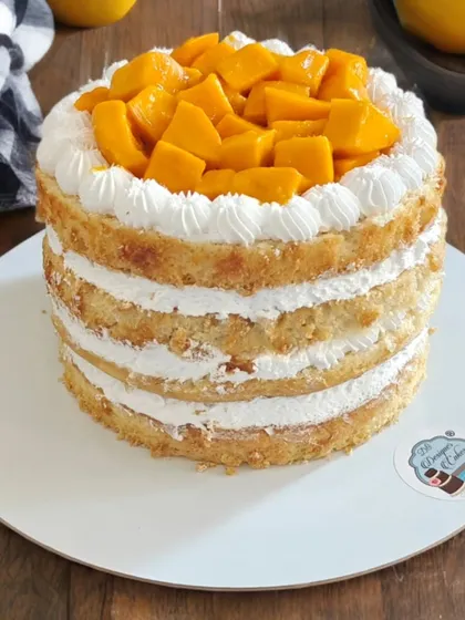 A naked mango cake with layers of sponge and fresh whipped cream, topped with juicy mango chunks. A seasonal favorite that's light and delicious.