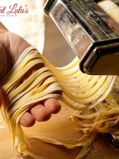 Holding a handful of freshly made fettuccine. This is the start of something beautiful and delicious. You can't beat the taste of handmade pasta.