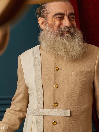 A joyful moment captured in our beige draped sherwani. The smile says it all; when you feel good in what you wear, it shows.