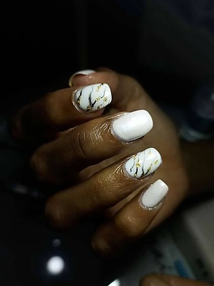 How chic are these marble nails? This design is perfect for someone looking for something classy, with white marble, black veins, and gold glitter accents.