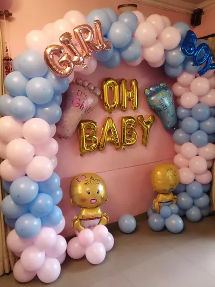 An 'Oh Baby' themed backdrop perfect for gender reveals, with pink and blue balloons, 'Boy' and 'Girl' foil balloons, and cute baby props.