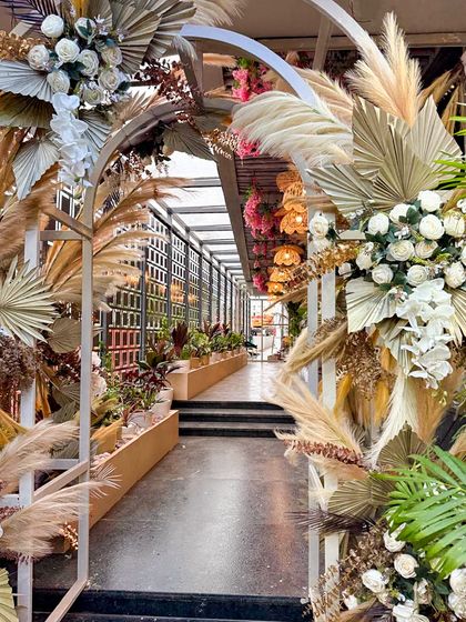 A decorative archway made of dried palms and flowers at Organic Creamery. This feature serves as a beautiful photo opportunity and reinforces the cafe's natural, artisanal aesthetic.