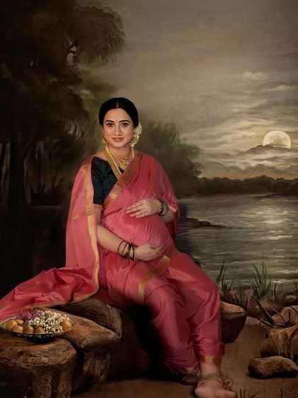 A painterly portrait of an expecting mother in a pink saree, set against a moonlit lake backdrop. This artistic photo evokes the style of a classic Raja Ravi Varma painting.