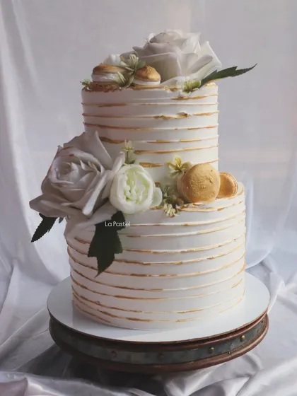 This two-tier cake combines a rustic striped texture with elegant gold accents. I finished it with white roses and gold-dusted macarons for a touch of Parisian chic.