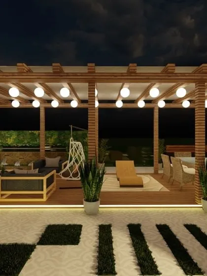 A night view of a large terrace with a wooden pergola and multiple seating areas. The globe string lights and illuminated pathways create a warm and inviting ambiance for large gatherings.