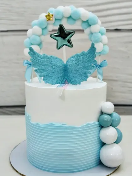 Soft blue and white, angel wings, and a shiny star. This dreamy baby shower cake is perfect for welcoming a little angel.