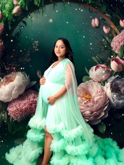 A stunning portrait in our mint green ruffled gown, set against a magical floral arch backdrop.