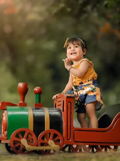 A sweet, shy moment during her toy train photoshoot. Even the quiet moments are beautiful, showing a different side of your child's personality.