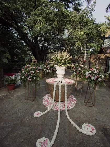 A stone well decorated with jasmine garlands and floral arrangements, a unique and beautiful decor element.