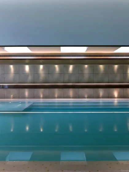 This sleek indoor swimming pool is a private sanctuary for year-round wellness. We designed the space with clean lines, sophisticated wall textures, and integrated ceiling lights that reflect beautifully on the water's surface, creating a calm and luxurious atmosphere.