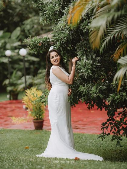 A lovely portrait of the bride standing in a garden, her smile radiant and her pose elegant.