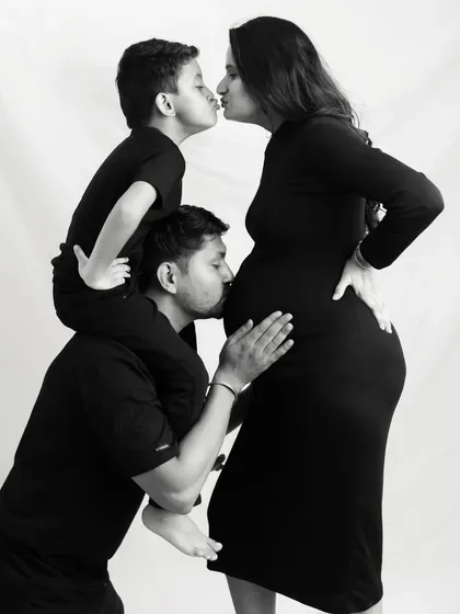 And then there were four. This black and white family portrait is so special, with kisses for mom and the baby bump from everyone. It’s a timeless way to capture the love that fills your home.