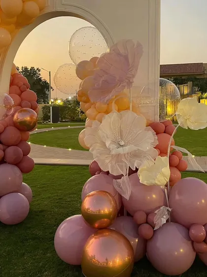 A close-up of the delicate, handcrafted paper flowers mixed with metallic and pastel balloons.