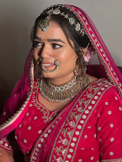 A side profile of the bride, highlighting her elegant updo and the way the dupatta frames her face. The makeup is balanced to look perfect from all angles.