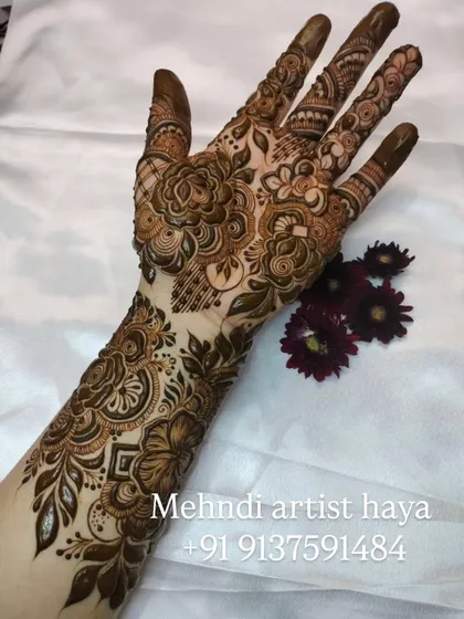 A full bridal arm piece with a beautiful combination of flowers, leaves, and traditional Indian motifs, perfect for a grand wedding celebration.