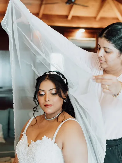 A behind-the-scenes shot of me placing the veil. This is a crucial final step to complete the bridal transformation, ensuring the veil sits perfectly.