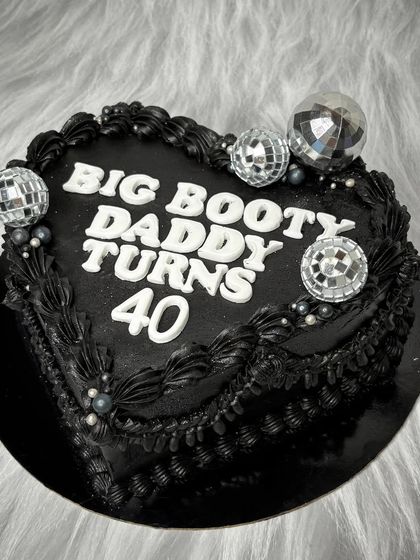 This one is for the "Big Booty Daddy" turning 40. A black heart-shaped cake with bold lettering and disco balls is the perfect way to celebrate a milestone with style and a bit of cheekiness.