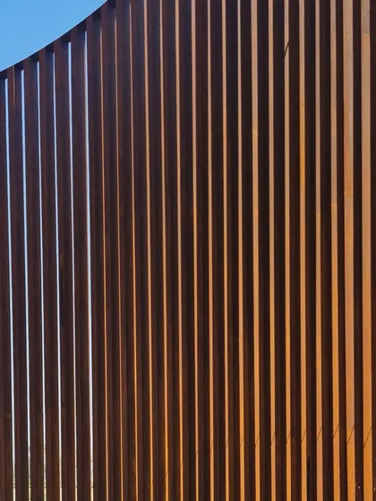 The clean, repeating lines of the Corten steel fins create a powerful graphic quality.