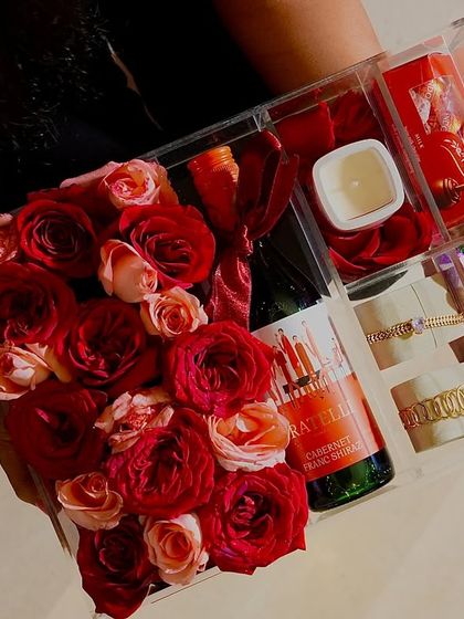 A close-up of the "Love Affair 2.0" hamper, held to show the rich colors and textures of the roses, wine, and chocolates. It’s a feast for the eyes.