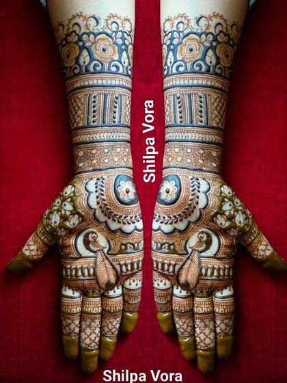 A beautiful symmetrical design with peacock paisleys and floral bands on the wrists.