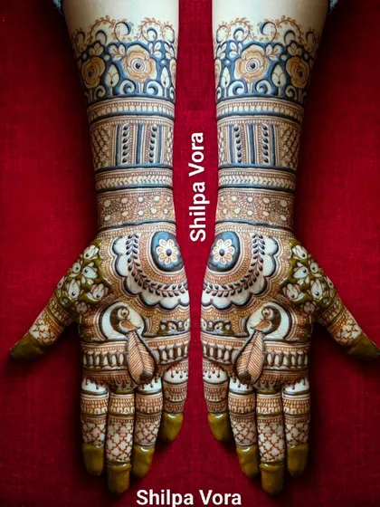 A beautiful symmetrical design with peacock paisleys and floral bands on the wrists.