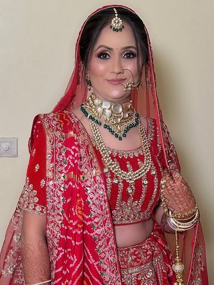 A portrait of elegance. This minimal makeup look enhances her natural beauty, proving that a red lehenga can be paired with a subtle face for a timeless effect.