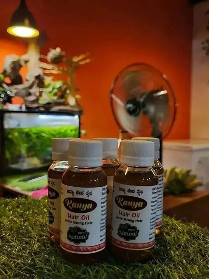 A creative shot of my hair oil bottles placed on artificial grass, with an aquarium in the background.