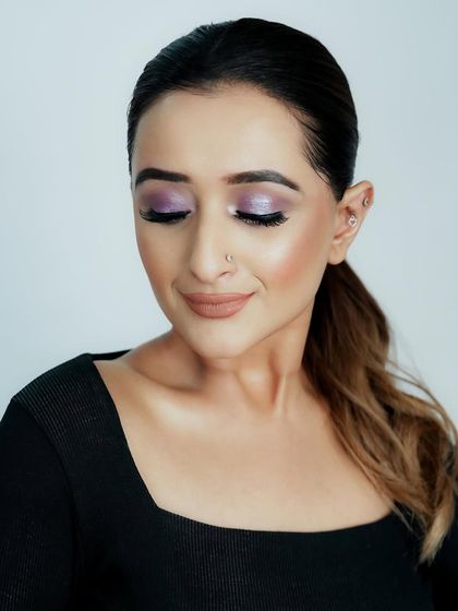 An eyes-closed shot to showcase the full effect of the metallic lilac eyeshadow, a trendy and eye-catching choice.