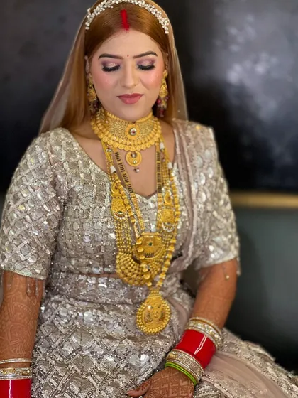 The same bride, showing her full outfit. The silver and gold lehenga is paired with a soft, glamorous makeup look.