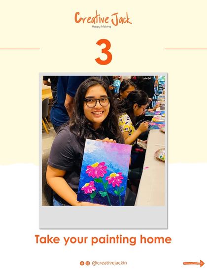 A smiling participant holds up her finished floral painting. A key benefit of my workshops is that you always get to take your unique creation home with you.