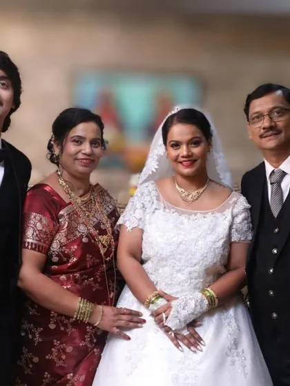 A lovely bride celebrating with her family. Her look features a classic red lip, which adds a beautiful pop of color against her white wedding dress, and a simple, elegant updo.
