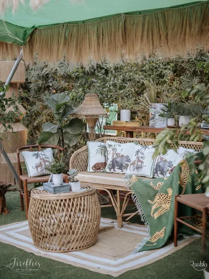 A cozy lounge area at the safari party, featuring a rattan sofa, animal-print cushions, and a custom-printed throw blanket. The entire setup was designed to feel comfortable and deeply personal.