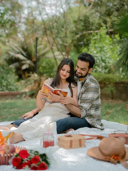 The couple sharing a book during their picnic shoot, a lovely way to incorporate shared hobbies into a pre-wedding session.