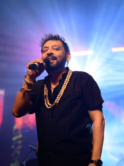 A singer lost in his music on stage, captured in a moment of pure performance under the concert lights.