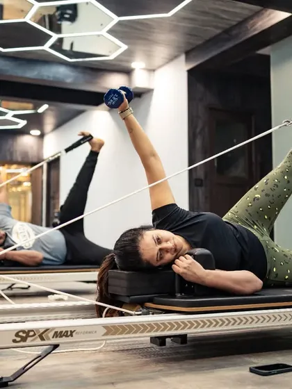 This side-lying leg series on the reformer targets the outer thighs and glutes. Using dumbbells adds an upper body challenge, making it a full-body exercise.