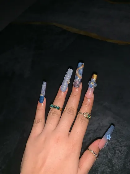 A full hand view of the stunning and dramatic water-themed nail extensions.
