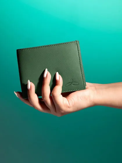 A simple, clean shot of a hand holding a green wallet. This straightforward approach clearly shows the product's size, color, and texture, making it ideal for e-commerce.