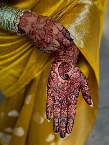 A close-up of the rich henna stain, showing the intricate details of the paisley design.