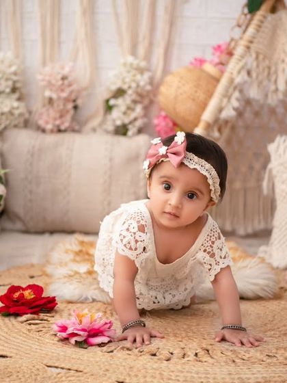 A beautiful sitter session in a floral boho setting. The lace romper and jute mat complement the rustic elegance of the backdrop perfectly.