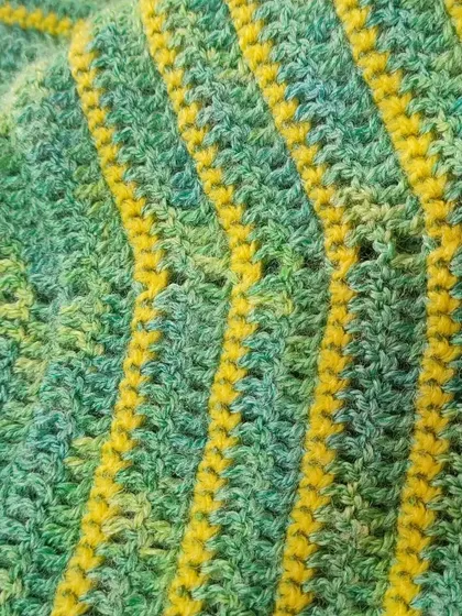 A close-up of the striped pattern on the lime green and yellow shawl.