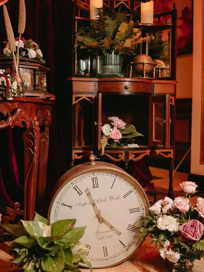 A vintage corner setup with an oversized clock and curated antique furniture.