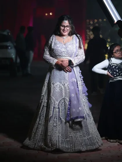 A candid moment of a happy bride in a beautiful silver-grey lehenga. The delicate lavender dupatta adds a soft touch of color to the ensemble.
