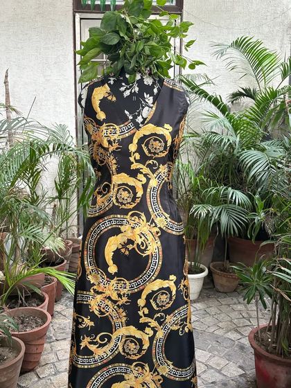 A full-length view of the made-to-order black and gold dress. This versatile piece can be dressed up or down, making it a valuable addition to any wardrobe.