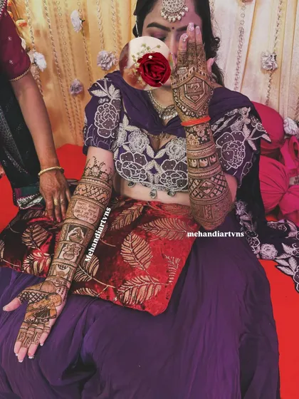 For this bride, we designed full-arm mehandi that tells her story through different panels, combining traditional motifs with personal moments. This is a perfect example of narrative bridal henna.
