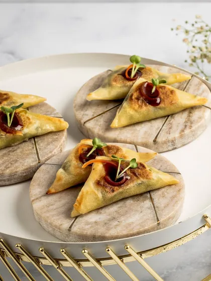 Our Spinach & Shiitake Samosettes are a modern twist on a classic. These crispy, triangular pastries are drizzled with a rich balsamic-soy reduction for an irresistible flavour.