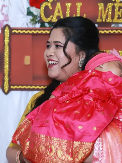 A mother's joyful smile as she holds her baby during a naming ceremony. These traditional events are full of love and emotion, and I focus on capturing the happiness of the family.