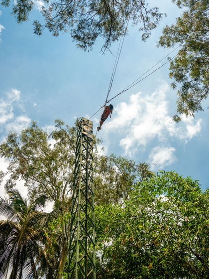 A low-angle shot of the Rocket Ejector, showing a participant at the peak of the ride against the sky.