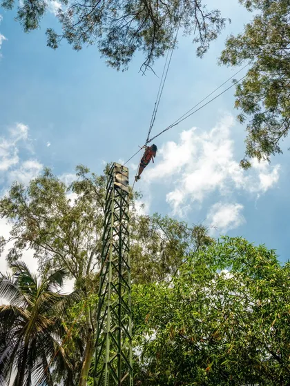 A low-angle shot of the Rocket Ejector, showing a participant at the peak of the ride against the sky.